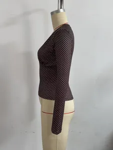 Vista de perfil de un top ajustado marrón con lunares y mangas largas en maniquí.