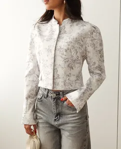 Close-up of a stylish women's short blazer with grey ink floral print and long sleeves