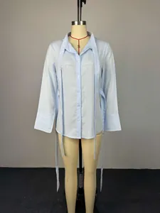 Vista de detalle de camisa de rayas azul claro con mangas largas y cintas elegantes