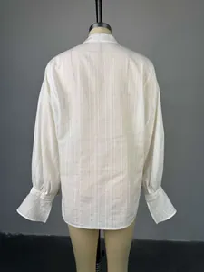 Vista trasera detallada de camisa blanca con cuello alto y mangas tipo farol