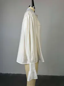 Vue latérale d'une chemise blanche ample à manches lanternes et poignets à volants