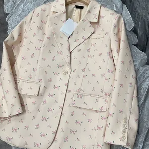 Detail of a sweet floral print blazer with a classic notched lapel and flap pockets.