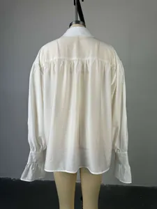 Vue arrière détaillée d'une chemise blanche à manches lanternes et poignets froissés
