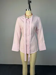 Detalle frontal de camisa entallada a rayas rosas con cuello de bufanda en maniquí