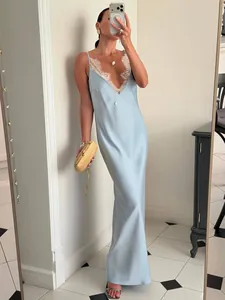 Détail d'une robe longue en satin bleu clair avec bordure en dentelle blanche sur le décolleté
