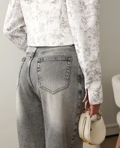 Detail of a women's cropped blazer featuring a grey ink-wash floral print and button cuffs.