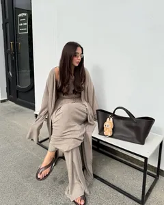 Dettaglio dell'elegante set tre pezzi con cardigan lungo e pantaloni a gamba larga