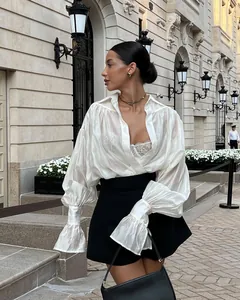 Élégante chemise blanche à manches lanternes et revers sur mannequin en décor urbain