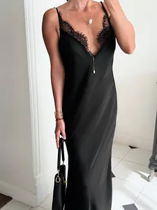 Détail d'une robe nuisette en satin noir avec dentelle délicate au décolleté