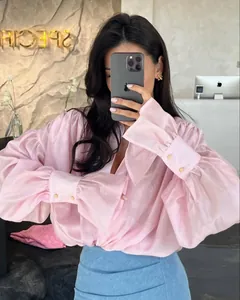 Détail d'un chemisier rose à manches lanternes avec col à revers et poignets boutonnés