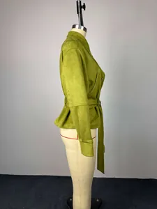Vista lateral detallada de una chaqueta corta verde oliva con cuello alto y cinturón