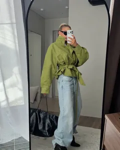 Elegante gabardina corta verde con cuello alto y cinturón en un selfie de espejo