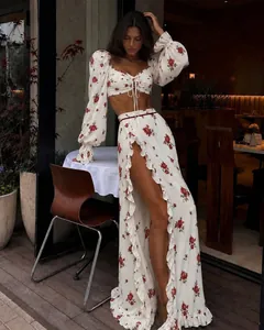 Elegant white floral two-piece set featuring lace-up crop top and ruffled high-slit skirt