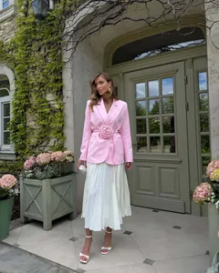 Detailed view of pink blazer with 3D flower embellishment and white pleated skirt set