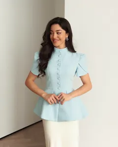 Vista completa dell'elegante camicetta peplum azzurra con colletto e bottoni