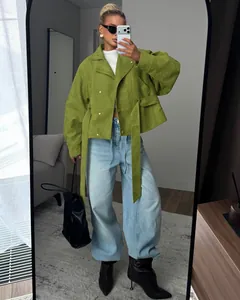 Selfie de cuerpo entero de una modelo con una gabardina corta verde con cinturón