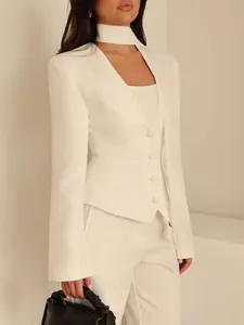 Gros plan d'un ensemble 3 pièces blanc avec blazer col V et écharpe assortie.