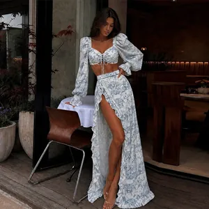 Elegant floral print two-piece set with tie-front crop top and high-slit maxi skirt.