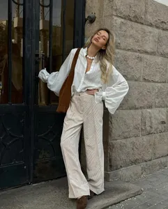 Elegant woman wearing a minimalist white long-sleeve lantern-sleeve shirt in a city street