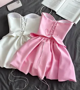 Detailed view of elegant strapless pink and white tops featuring lace-up corset back design.
