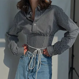 Detailed view of striped long sleeve shirt featuring a corset waist with white lacing