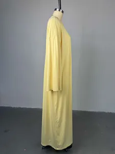 Vista laterale di un abito lungo giallo chiaro a maniche lunghe su un manichino.
