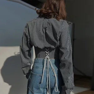 Detailed view of a striped cropped shirt featuring an elegant lace-up corset back