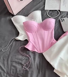 Detailed view of sexy pink and white corset-style tube tops on a gray fabric background.