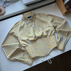 Close-up of yellow striped cropped shirt with unique cinched waist and button-down details.