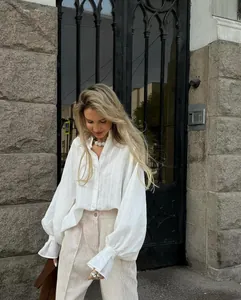 Chic white loose-fitting long-sleeve blouse with subtle vertical texture and lapel collar
