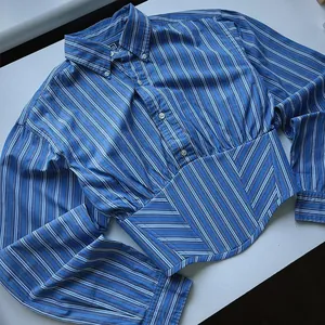 Detailed view of a blue striped cropped shirt with a corset-style waist and long sleeves.