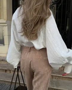 Back view of a loose white long-sleeve shirt with textured fabric and puff sleeves