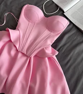 Detail view of a pink corset-style top with structured seams and ruffles.
