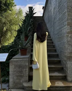 Vista posteriore di un lungo cardigan giallo con vestibilità comoda per un look estivo