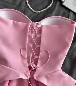 Close-up detail of a pink strapless corset-style top featuring an elegant lace-up back design