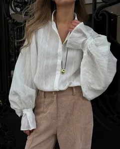 Close-up detail of white lantern sleeve shirt featuring delicate vertical striped texture