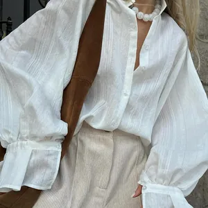 Elegant white long-sleeved button-up shirt with vertical textured stripes and lapel collar