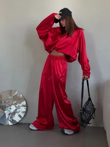 Vibrant red satin tracksuit set with wide-leg pants and loose oversized jacket.