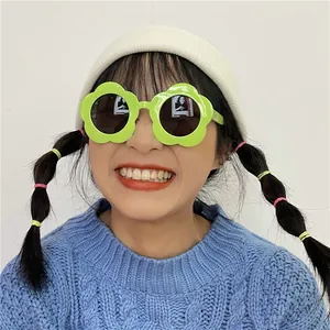 Occhiali da sole divertenti a forma di fiore verde indossati da una modella per feste.