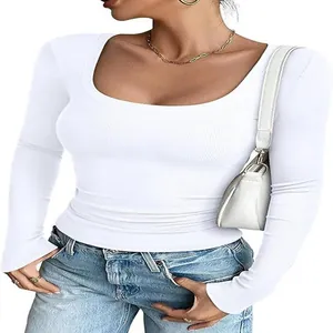 Detalle de top blanco de manga larga con cuello en U y tejido de punto acanalado.