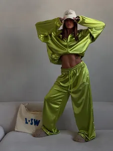 Fashionable neon green satin tracksuit featuring a zip-up hoodie and wide-leg sports pants