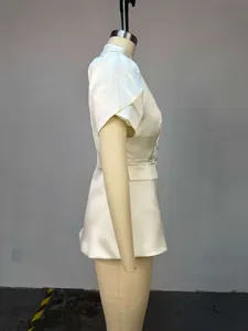Profilo laterale di un elegante blazer in raso crema con maniche a sbuffo e vita stretta