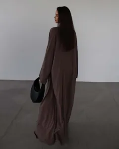 Vista posteriore di un elegante set cardigan lungo marrone e pantaloni a vita alta coordinati