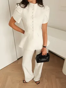 Vista dettagliata di un elegante blazer bianco a baschina con maniche corte a sbuffo