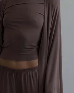 Dettaglio di un set da casa tre pezzi con cardigan lungo e pantaloni a vita alta.