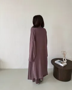 Vista posteriore di un cardigan lungo color malva e un set di pantaloni a vita alta