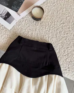 Vista detallada de la falda mini línea A en contraste de negro y crema.