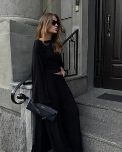 Elegante completo relax nero 3 pezzi con cardigan lungo e pantaloni larghi su modella.