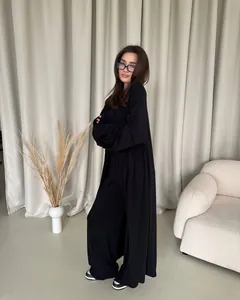 Elegante completo nero due pezzi con cardigan lungo e pantaloni a gamba larga a vita alta.