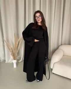 Elegante completo tre pezzi nero da donna con cardigan lungo e pantaloni a gamba larga.